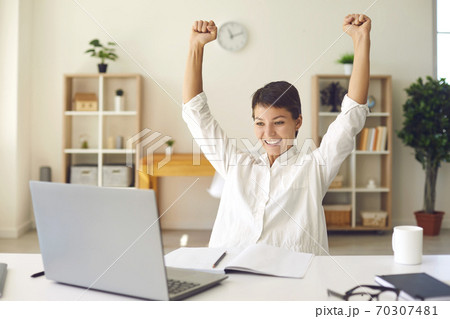 Successful businesswoman raises her hands up rejoices in increasing profits in business. Successful businesswoman raises her hands up rejoices in increasing profits in business. 70307481