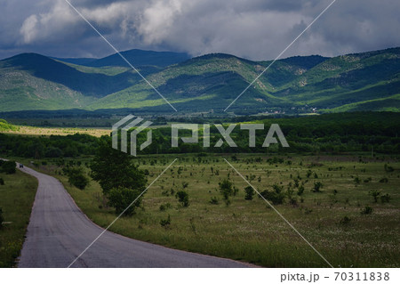 Beautiful country road before a thunderstorm at sunset. Beautiful country road before a thunderstorm at sunset. 70311838
