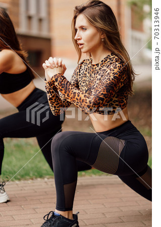 girls athletes in sports apparel, doing lunges 70313946