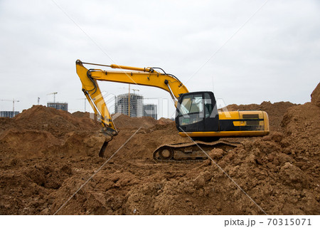 Excavator during earthworks at construction site. Backhoe digging the ground Excavator during earthworks at construction site. Backhoe digging the ground 70315071