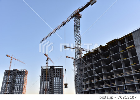 Tower crane lifting bucket for pouring concrete during construction new residential building Tower crane lifting bucket for pouring concrete during construction new residential building 70315107