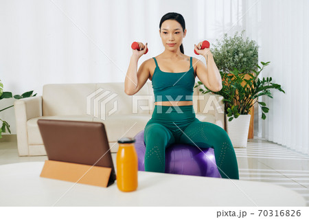 Woman exercising with dumbbells Woman exercising with dumbbells 70316826
