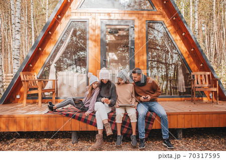 Happy family sitting on the terrace of their house in autumn 70317595