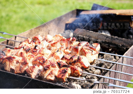 Meat skewers on skewers are grilled in the open air Meat skewers on skewers are grilled in the open air 70317724