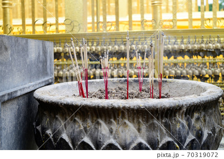 Incense sticks burning in old pot in the temple for worship of buddha Incense sticks burning in old pot in the temple for worship of buddha 70319072
