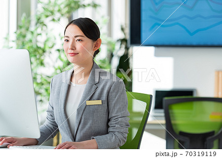 明るいオフィスの窓側でパソコン操作する若いビジネスウーマン 明るいオフィスの窓側でパソコン操作する若いビジネスウーマン 70319119