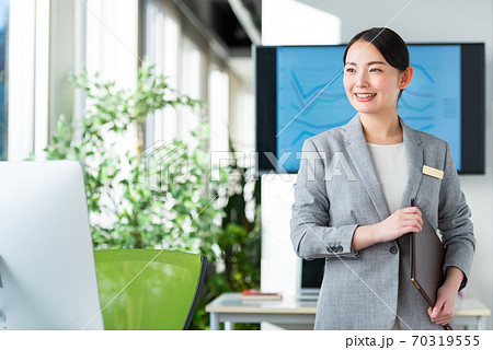 明るいオフィスで仕事をするビジネスウーマン 70319555