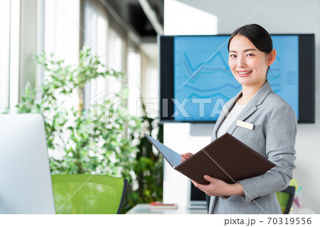 明るいオフィスで仕事をするビジネスウーマン 70319556