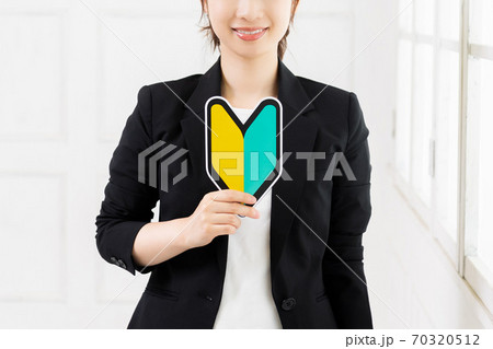初心者マークを持つ若いビジネスウーマン 初心者マークを持つ若いビジネスウーマン 70320512