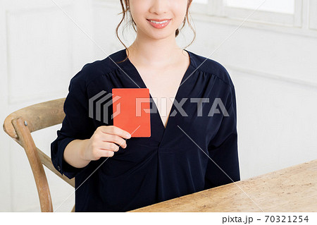 レッドカードを手に持つ若い女性 レッドカードを手に持つ若い女性 70321254