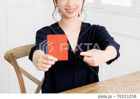 レッドカードを手に持つ若い女性 70321256