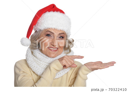 Portrait of smiling happy senior woman in Santa hat posing 70322410