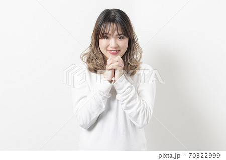 お願いのジェスチャーをする若い女性 お願いのジェスチャーをする若い女性 70322999