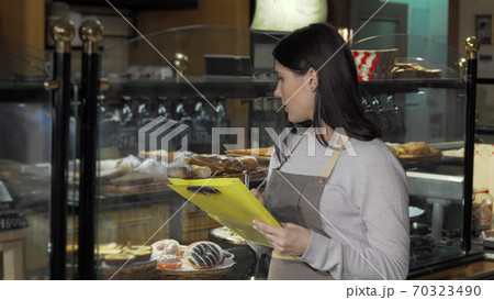 Young female baker working at her store Young female baker working at her store 70323490