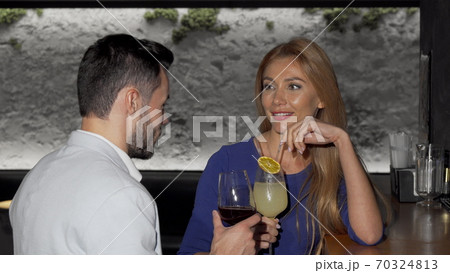 Beautiful woman having drinks with her boyfriend at the bar 70324813