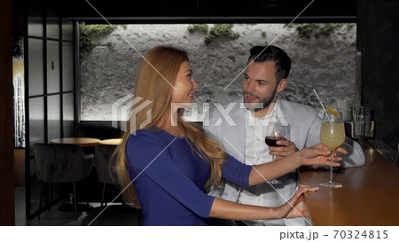Handsome man enjoying drinks with his girlfriend at the bar Handsome man enjoying drinks with his girlfriend at the bar 70324815