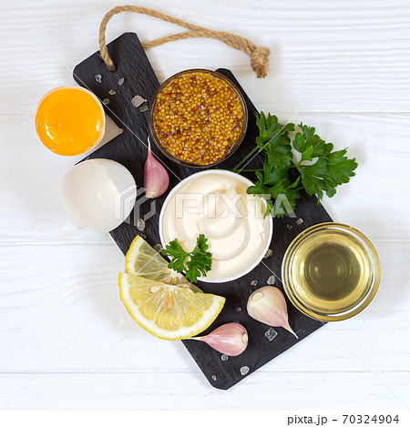 Ingredients for making mayonnaise sauce on stone board top view 70324904