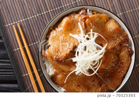 Butadon pork bowl, is a Japanese dish consisting of a bowl of rice topped with pork simmered in a mildly sweet sauce close-up in a bowl. Horizontal top view Butadon pork bowl, is a Japanese dish consisting of a bowl of rice topped with pork simmered in a mildly sweet sauce close-up in a bowl. Horizontal top view 70325303