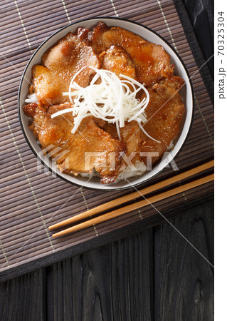 Japanese Butadon pork rice bowl close-up in a bowl. Vertical top view Japanese Butadon pork rice bowl close-up in a bowl. Vertical top view 70325304