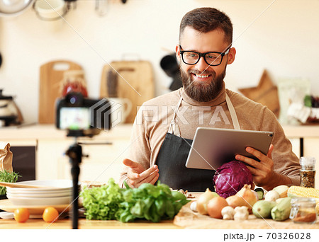 Happy food blogger recording video recipe of healthy food. 70326028