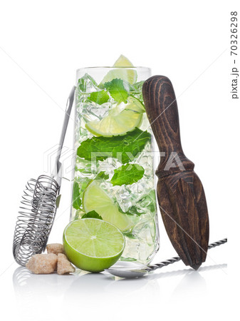 Glass of Mojito summer alcoholic cocktail with ice cubes mint and lime on white with strainer 70326298