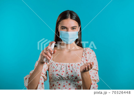 Woman in protective mask applies disinfectant antiseptic to her hands. Stop virus concept, bacteria 70326448