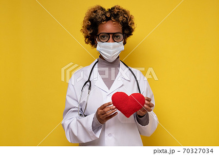African female doctor holding a heart smiling African female doctor holding a heart smiling 70327034