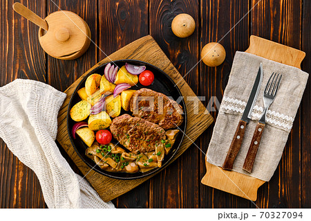 Fried beef fillet with potato wedges served with fresh onion, tomato and honey mushrooms gravy Fried beef fillet with potato wedges served with fresh onion, tomato and honey mushrooms gravy 70327094