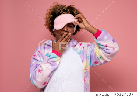 Yawning tired young african woman in pajamas. 70327337
