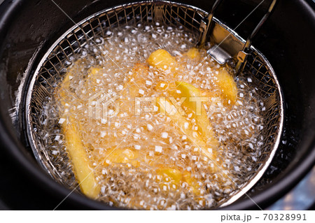 French fries. oil boiling in a deep fryer at home. 70328991