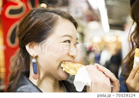 食べ歩きをする女性 70329124