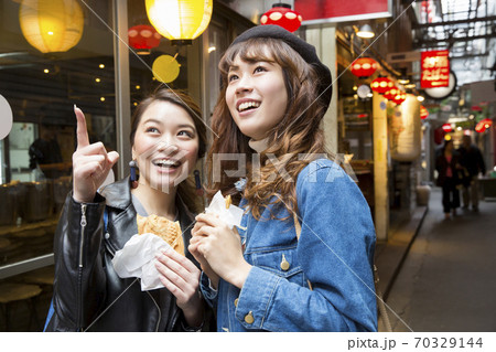 食べ歩きをする女性 食べ歩きをする女性 70329144
