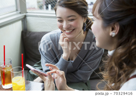 カフェで談笑する女性 70329416