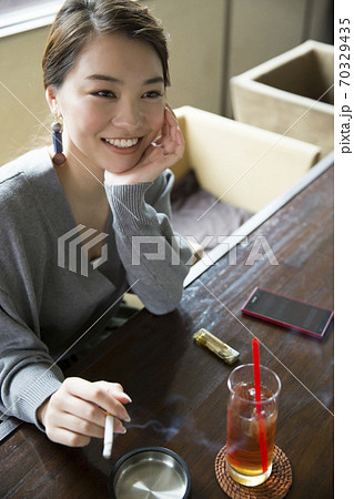 タバコを吸う女性 70329435