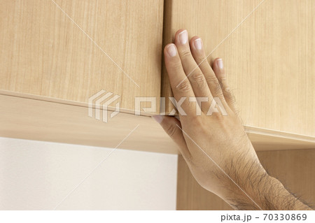 玄関の下駄箱を開ける男性の手 玄関の下駄箱を開ける男性の手 70330869