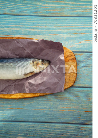 part whole salted herring on paper on wooden Board part whole salted herring on paper on wooden Board 70331201