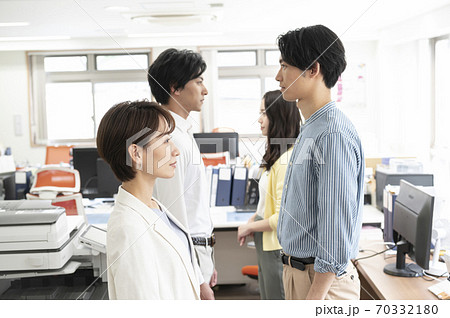 オフィースで向かい合わせで並ぶ男性女性 オフィースで向かい合わせで並ぶ男性女性 70332180