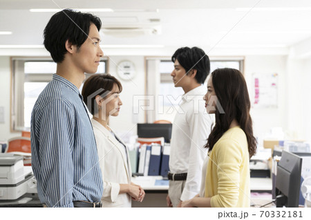 オフィースで向かい合わせで並ぶ男性女性 オフィースで向かい合わせで並ぶ男性女性 70332181