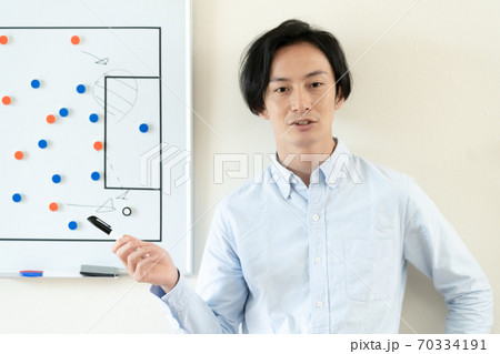 戦術を伝えるコーチの男性 70334191