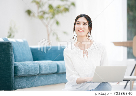 リビングでノートパソコンを使う若い女性 70336340