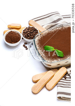 Traditional Italian Tiramisu dessert in glass baking dish and savoiardi cookies isolated on white 70336508