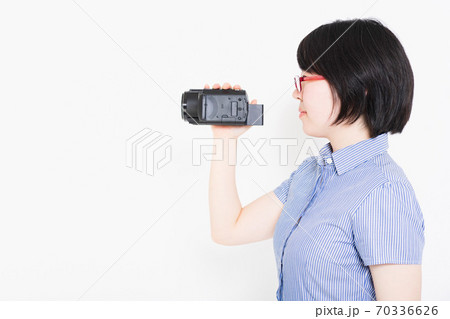 ビデオカメラで動画を撮影する女性の写真素材