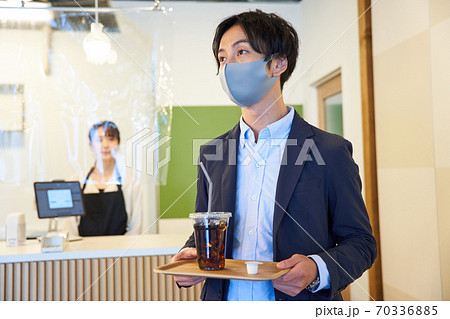 カフェでアイスコーヒーを買う青年 カフェでアイスコーヒーを買う青年 70336885