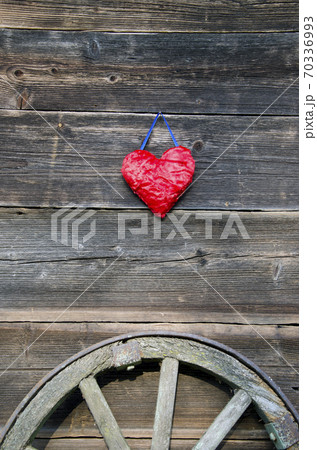 red heart symbol on old wooden barn wall and carriage wheel red heart symbol on old wooden barn wall and carriage wheel 70336993