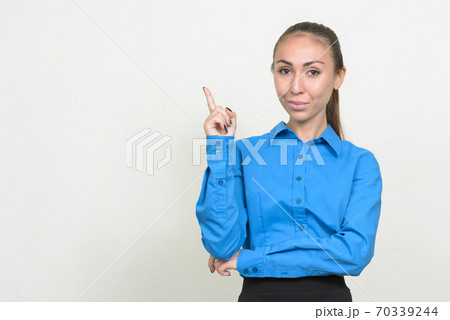 Portrait of young businesswoman with brown hair pointing up 70339244