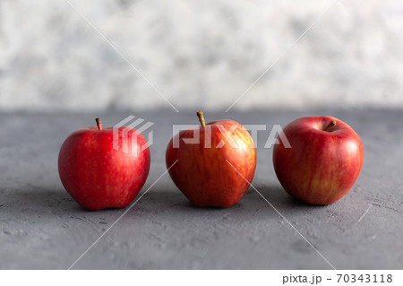 Ripe garden red apples on gray concrete. 70343118