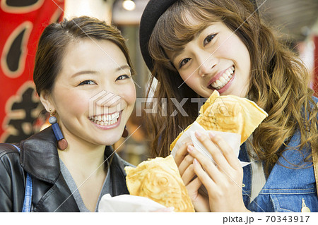 食べ歩きをする女性 70343917