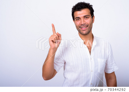Portrait of happy handsome Turkish man pointing up Portrait of happy handsome Turkish man pointing up 70344292