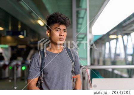 Young Asian tourist man as backpacker thinking at the sky train station 70345202