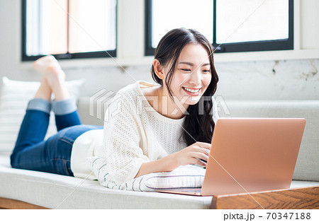 リビングでパソコンを操作する若い女性 70347188